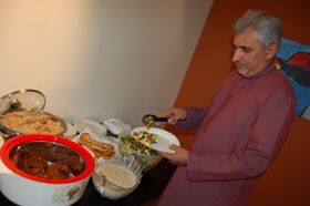 PAKISTANSK: Khalid Mahmood Malik forsyner seg av koltbordet dekket av tradisjonelle pakistanske retter: naan-brød, kylling, ris, og mye mer.