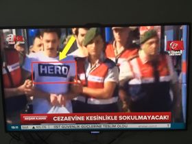 Gokhan Guclu, som skal ha tilført gruppen som skulle drepe Erdogan, blir ført til rettslokalet med tskjorten HERO. Skjermbilde A Haber.