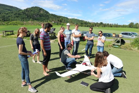 Teknologiske: Her jobber studentene med dronen som hvis mål er å følge et billøp helt på egen hånd. (Foto: Kongsberg Gruppen)