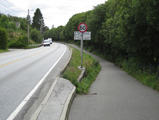 Eksempel 3. E 39 i Bergen kommune. Lav støpekant i yttersving der det er en bratt skråning og gangveg på utsiden av europavegen. Dårlig sikret rekkverksende.
