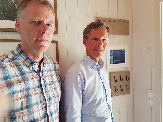 Bård Ståle Kvitberg, teknisk rådgiver xComfort og Jon Helsingeng, administrerende direktør står i ett av selskapets demohus og viser fram panelet som styrer smarthuset. Foto: Marte Ottemo