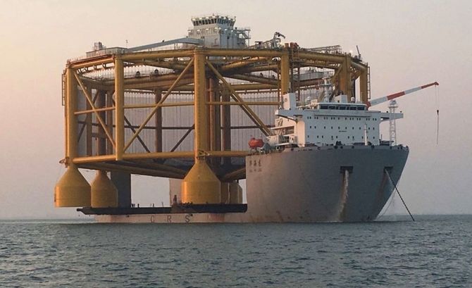 Ocean Farm1 måler 110 meter i diameter og stikker godt ut på sidene fra 43,6 meter brede og 182 meter lange Hua Hai Long..