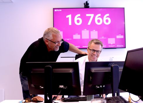 Ofte sett: Amedia-ledere foran rosa vegg med stort tall. Det forteller hvor mange som har registrert seg med aID på TA.no.