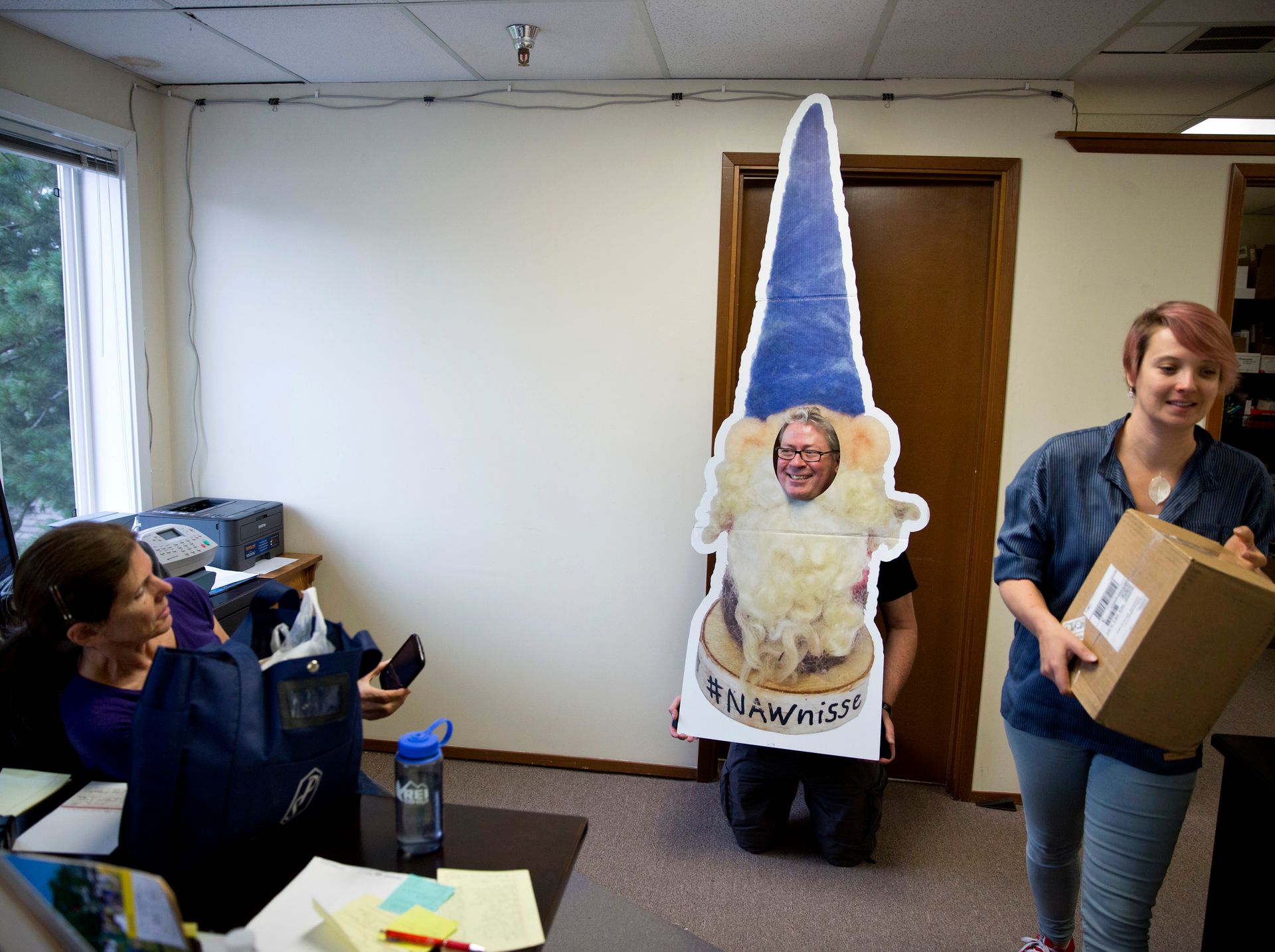 MEDIENISSE: The Norwegian American sin maskot er sjølvsagt ein fjøsnisse. Frå venstre: ofice assistant Deborah Stoner-Ma, office manager John Erik Stacy og redaktør Emily C. Skaftun. NAW står for Norwegian American Weekly, men no kjem avisa kun ut annakvar veke.