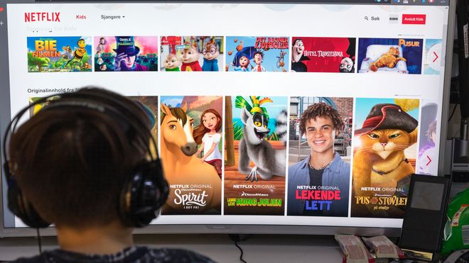 Gutt ser på Netflix på en stor skjerm.