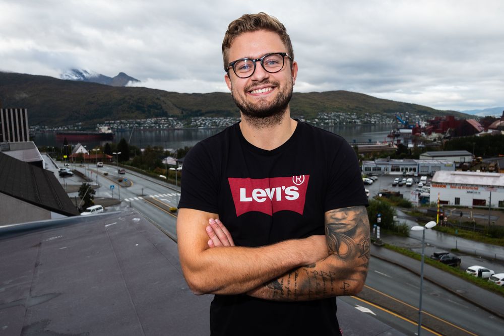 Andreas Haakonsen, nyhetsredaktør i Fremover, fotografert på taket av Fremover-bygget med utsikt over Narvik. For å komme seg til denne utsiktsposten må man lure seg rundt et hjørne med en 50 centimeter bred passasje. Haakonsen kan røpe at det er under halve redaksjonen tør å gå over den.