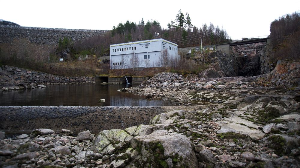 Elva Surna i Surnadal på Nordmøre er nasjonal lakseelv, men også regulert for kraftproduksjon. Det har vært flere konflikter mellom elveeiere, laksefiskere og kraftverkseier Statkraft. Bildet viser Gråsjø kraftverk, som utnytter fallet fra Gråsjøen til Follsjø. Gråsjødammen som vises bak kraftverket.