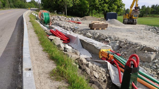 Graving av fiber langs en vei.