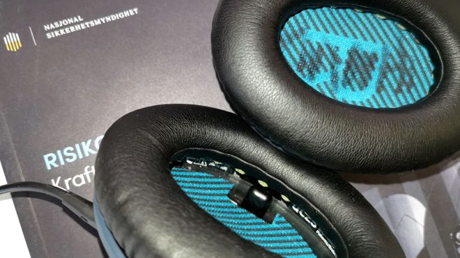 Bose QC 25 liggende oppå hefte fra Nasjonal sikkerhetsmyndighet