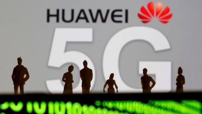Små leketøyfigurer foran logoer for Huawei og 5G. Binærkode vises nedenfor.