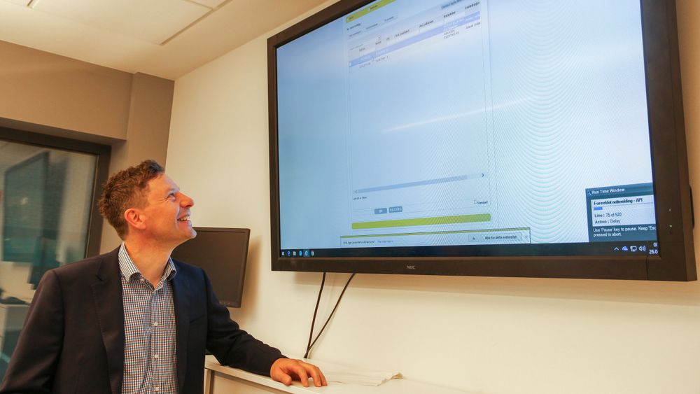 Svein Kristian Reiersen er fornøyd med at dataroboter tar over rutinearbeid. Her ser vi noe av aktiviteten RPA-1 utfører til høyre i bildet.