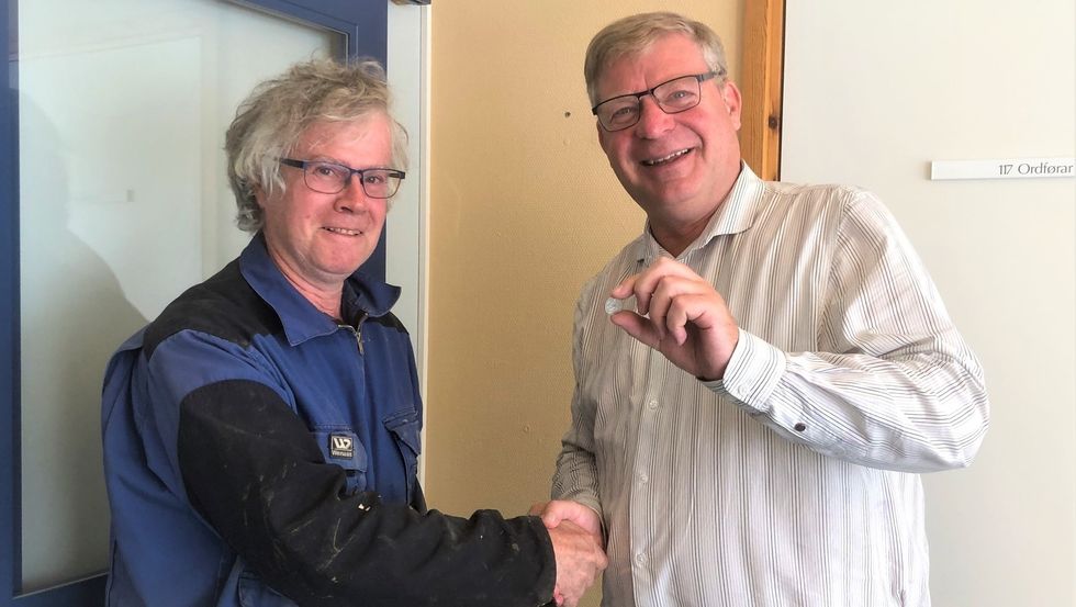 SYMBOLSK SUM: Ordførar i Auland kommune, Noralv Distad viser fram vinsten frå skulehussalet. Han meiner at dette salet var ein god deal for både kommunen og kjøpar Knut Olav Lie.