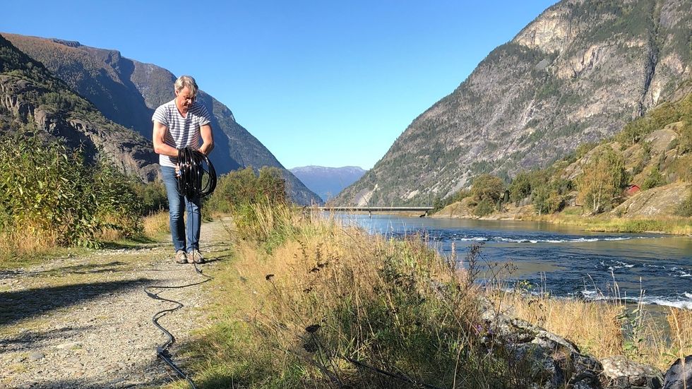UNDERVASSKAMERA: Anders Lamberg frå Skandinavisk naturovervakting jobber med installasjon av kameraene som skal registrera fisken i Lærdalselvi.