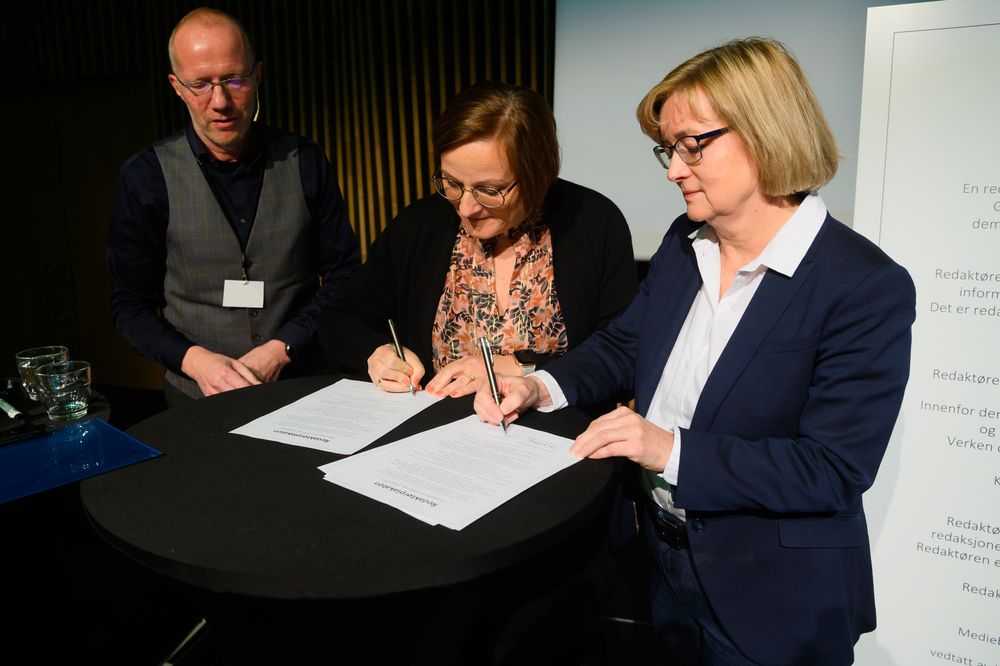 Tove Elin Nedreberg og Hanna Relling Berg signerer ny Redaktørplakat. Generalsekretær Arne Jensen i Norsk Redaktørforening til venstre. Her på Norsk Redaktørforening sitt høstmøte 2019.