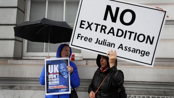 Demonstranter utenfor en domstol i London, med plakater med "No extradition – free Julian Assange".