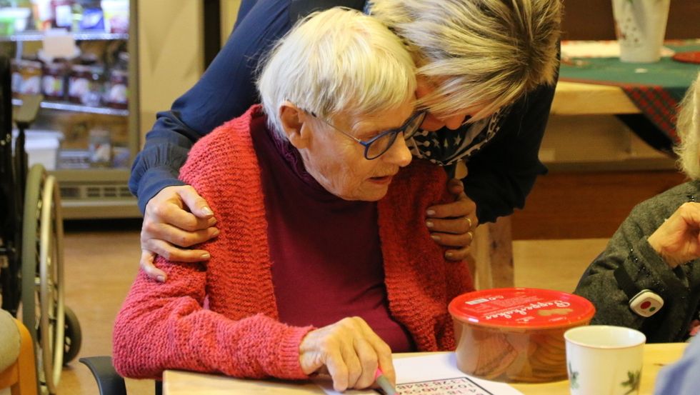 Aktivitør i Årdal Birgit Onsum er vert for fredagsbingoen. Her er ho saman med Solveig, som vann på fire rekker og fekk ein heil peparkakeboks i premie.