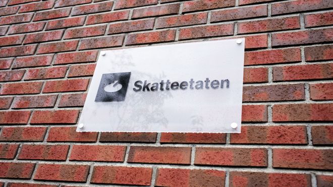 Skilt med Skatteetaten på murvegg. Foto.