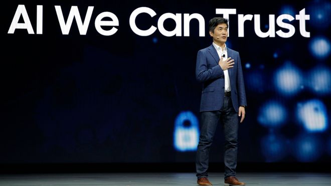 Sebastian Seung på scenen, med teksten "AI We can trust" på skjermen bak. Foto.