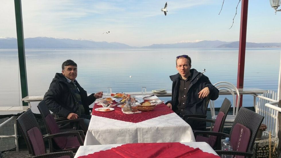 GOD UTSIKT: Den lokale guiden Aleksandar (t.v) og Snorre Sandemose (t.h) på lunsj ved Ohridsjøen i Nord-Makedonia.