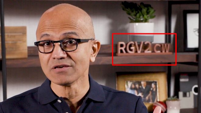 Satya Nadella under Build 2020 med en kode på hylla i bakgrunnen.