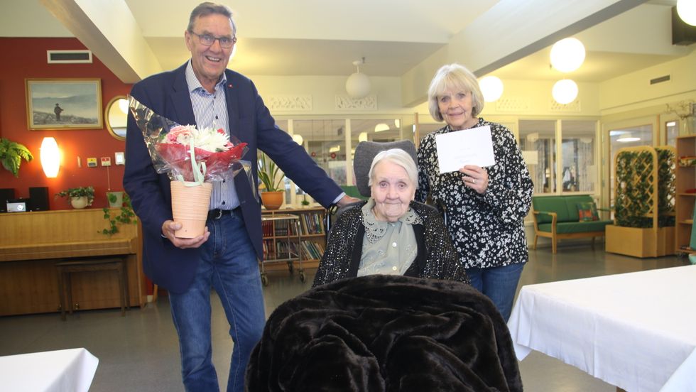 FEIRA: Sonen Kåre Hovland held ein blome, og dottera Åse Grihamar ei helsing frå Kongen. Tysdag feira Sigrid Hovland 100 år.