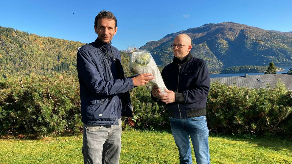 FAST TILSETT: Frode får blomster og gratulasjonar frå John Martin Høines, personalet sitt medlem i tilsetjingsutvalet.