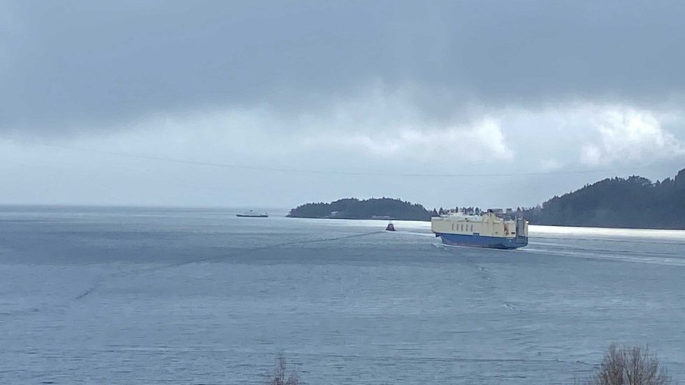 PÅ VEG: «Asian Emperor» har følgje av slepebåten «Stadt Kinn» på veg ut fjorden.