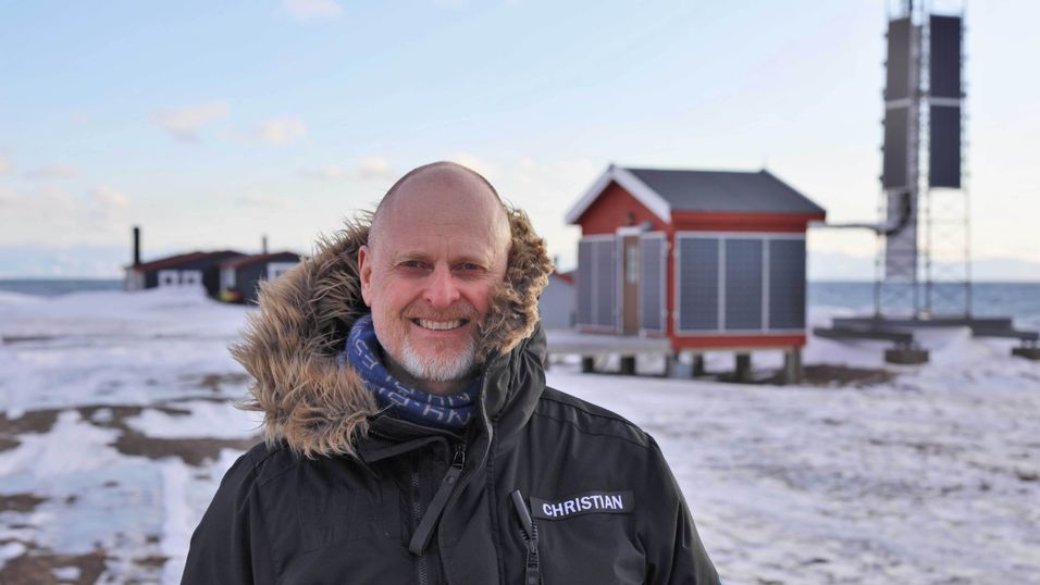 Christian Skottun, her foran en av basestasjonene på Svalbard. Allerede i 2019 tok Telenor Svalbard solenergi i bruk ved flere av sine basestasjoner for å redusere bruken av fossil energi.