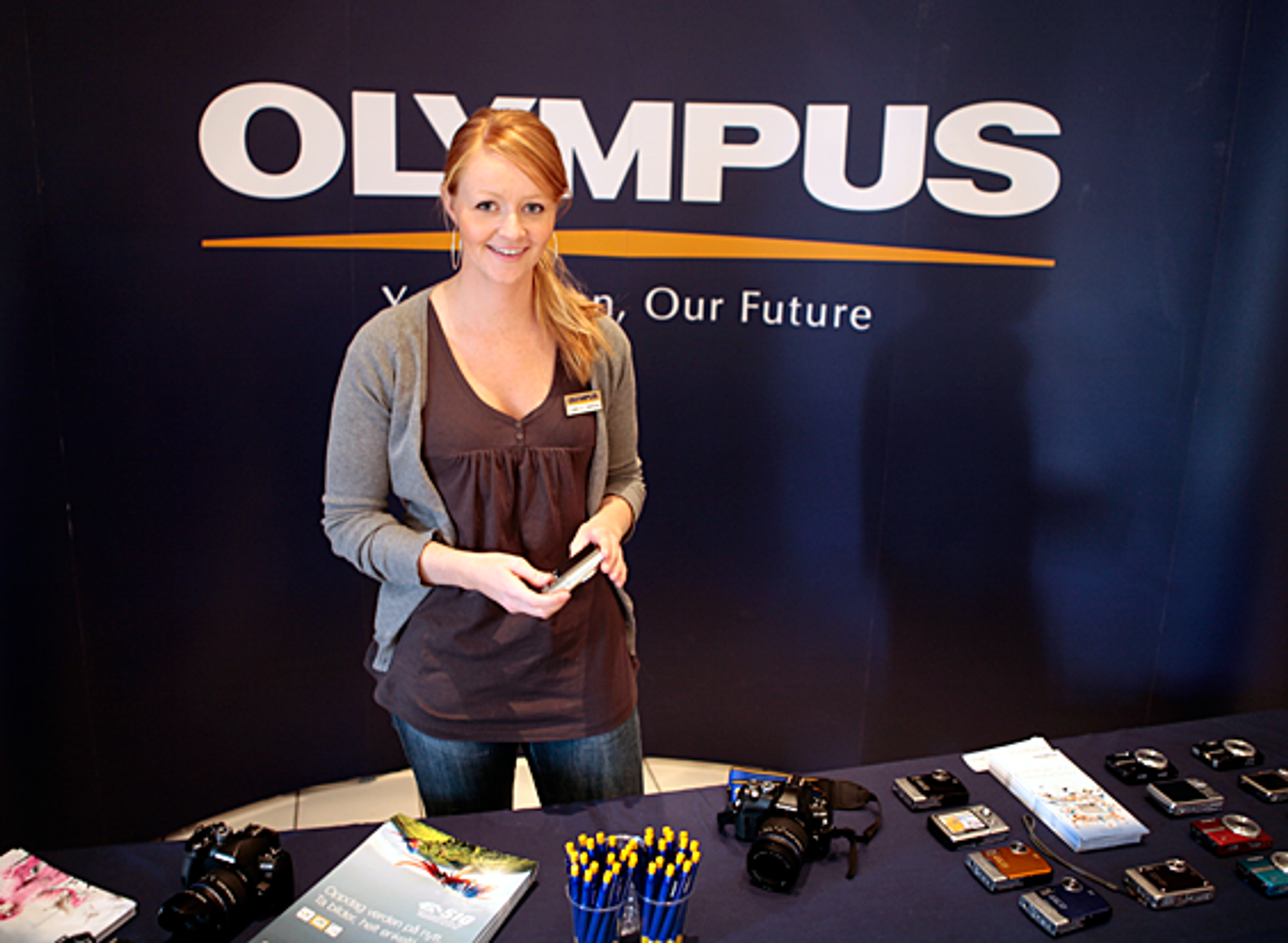 Camilla viser Olympus-produkter