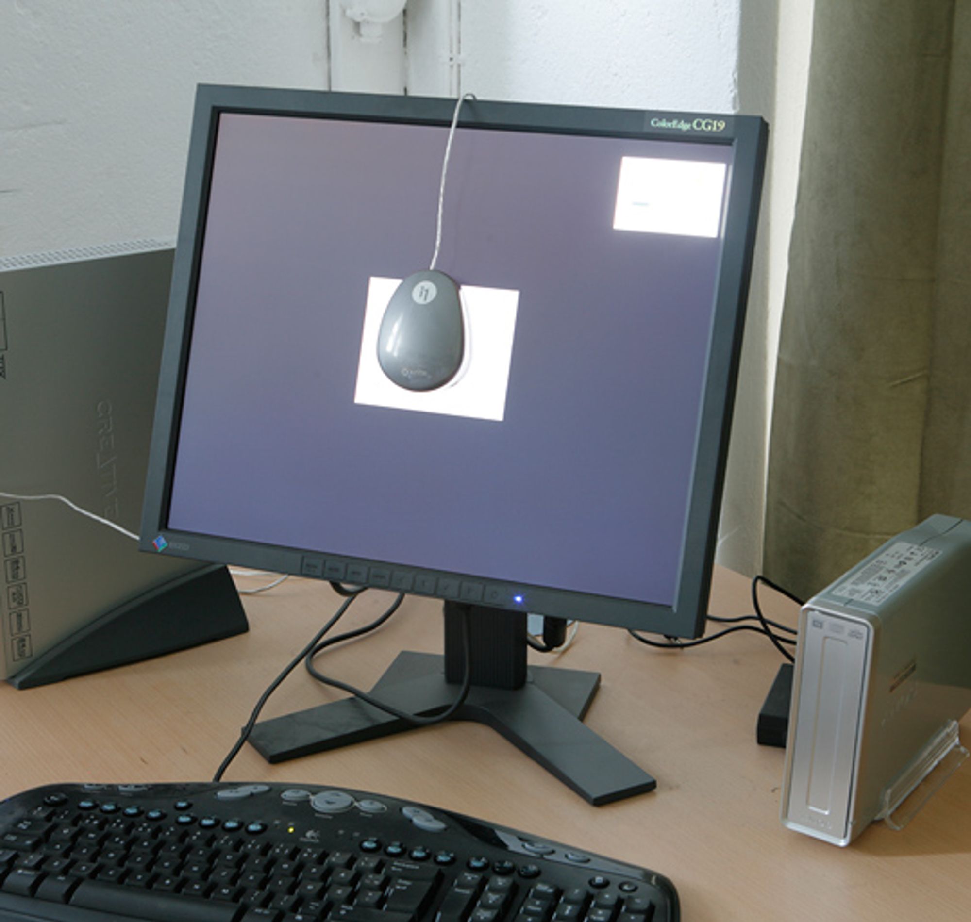 Eksempel på oppsett for kalibrering av skjerm. Kolorimeteret, i dette tilfellet ColorMunki, ligger an mot skjermen, slik at det kan "se" hva skjermen viser.