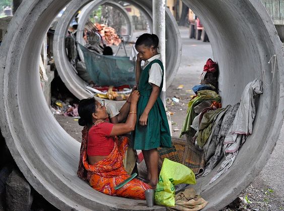 A homeless mother preparing to send her daughter to school in the morning, while her still sleepy son clings to her in India. Foto: Gautam Basu ( BULLS/EPOTY.ORG ) 