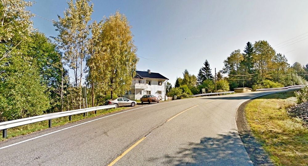 Huset til venstre må rives for å gi plass til gang/sykkelvegen. Det er ikke mange hus langs vegen, men den er en viktig skoleveg. (Foto: Google)