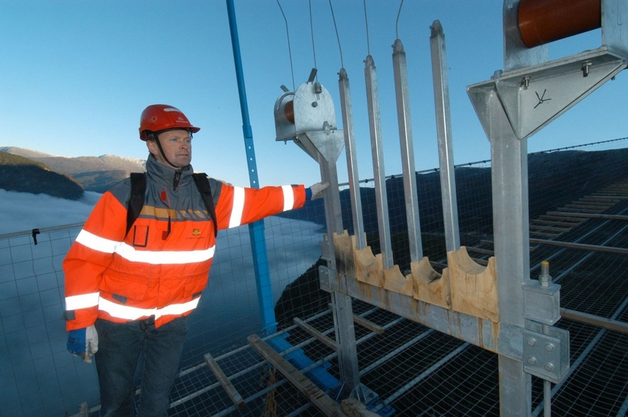 Assisterande byggjeleiar Ingar Fasteland i Statens vegvesen ved ein av kabelformarane ute på gangbrua, der tråden skal leggast inn. (