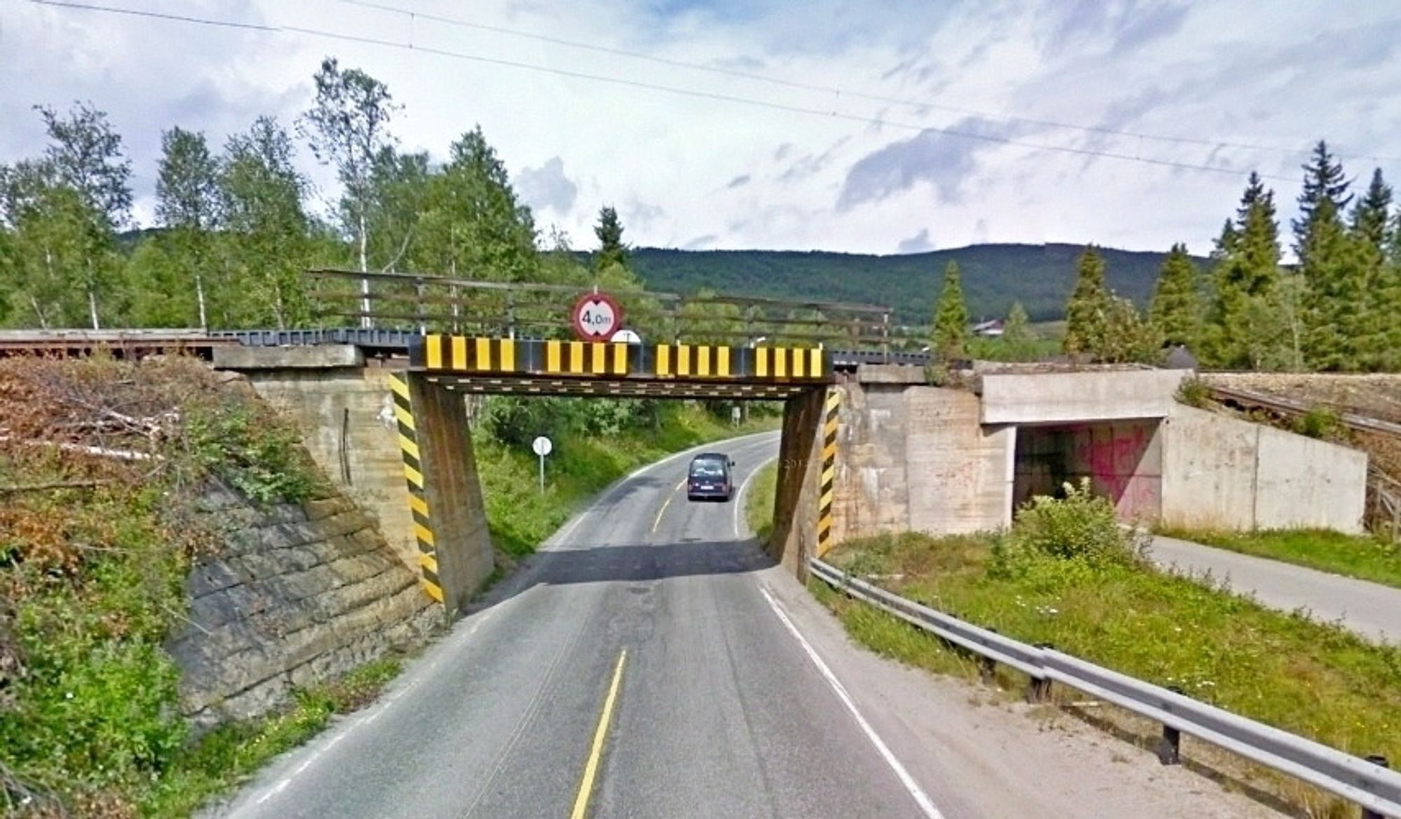 Fire meter frihøyde er for lite på en så viktig veg som riksveg 7. Denne jernbanebrua skal erstattes med en kulvert med full høyde og bredde. (Foto: Google)