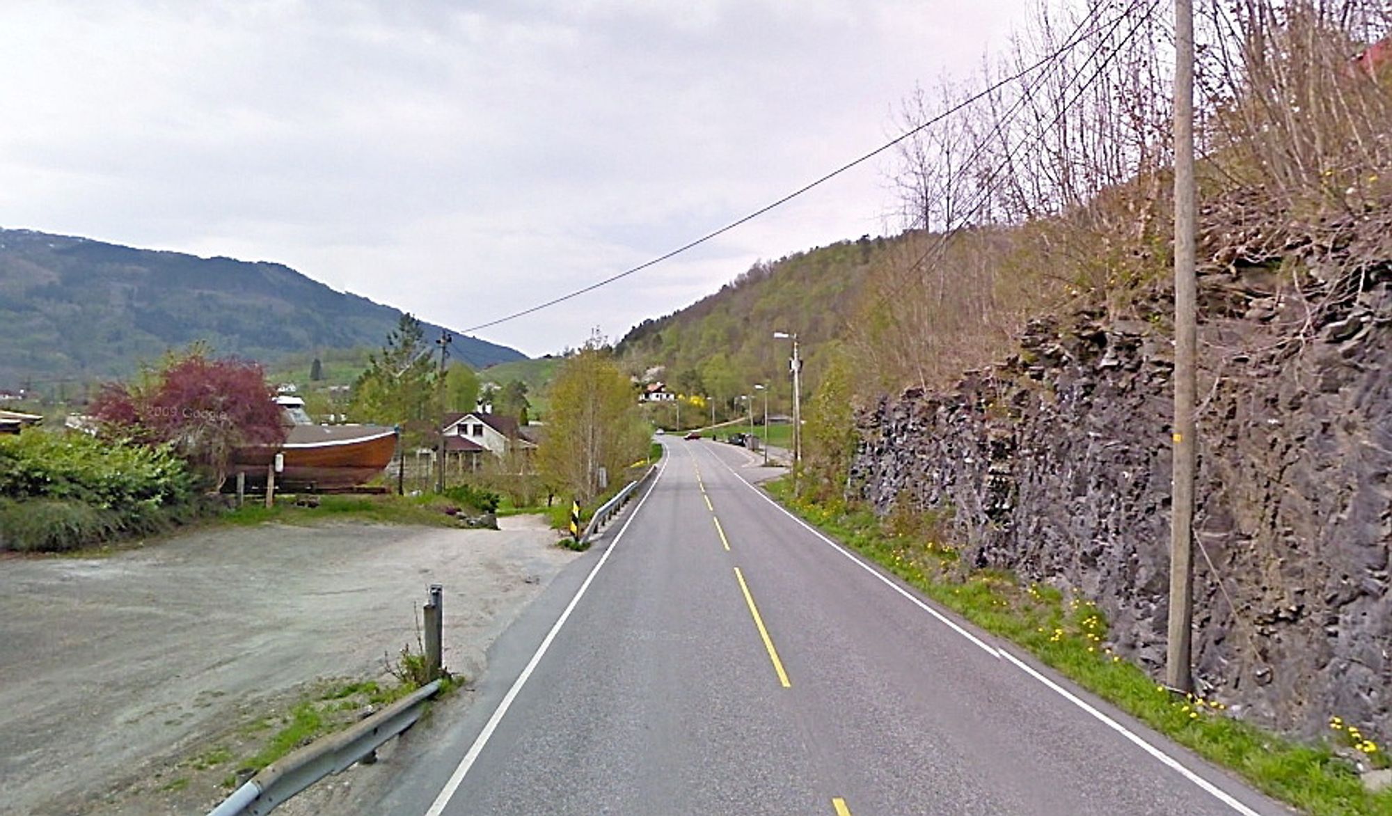 Utvidelsen av fylkesveg 7 skal skje mot skjæringen til høyre. 18 000 kbm skal tas ut på knapt 700 meter for  gi plass til utvidelse av fylkesvegen og en ny parallell kommunal veg. (Foto: Google)