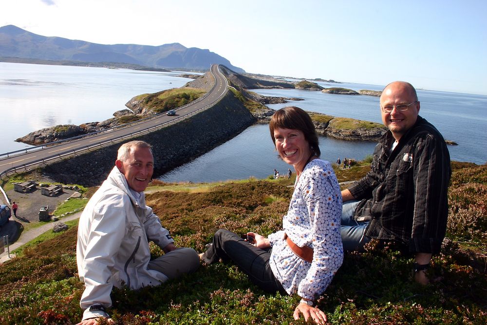 Grete Kongshaug på Atlanterhavsvegen, sammen med to veteraner i turistvegsammenheng Magne Flemsæter og Per Kolstad. (Foto: Kjell Herskedal)