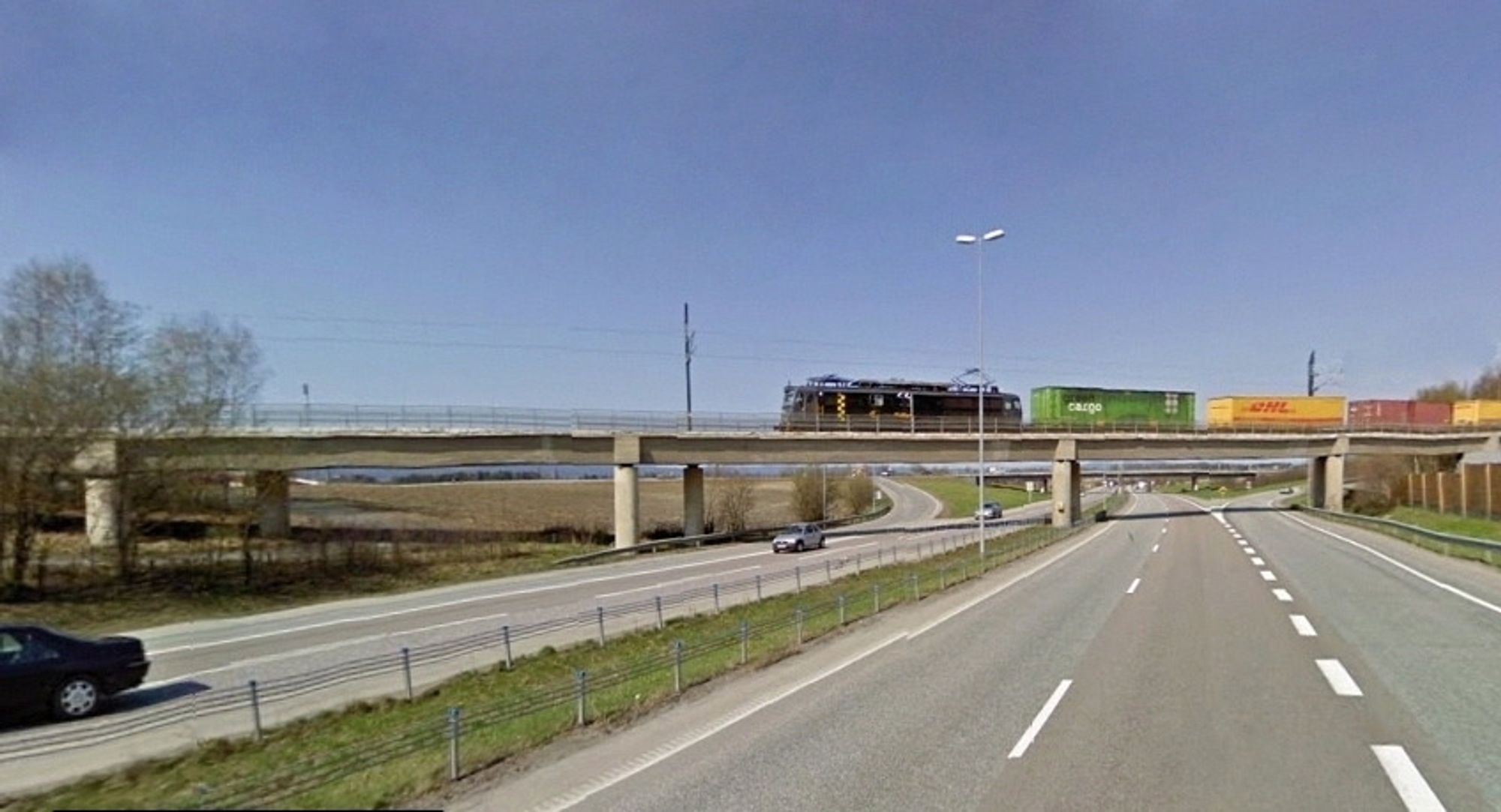 Brua som fører jernbanen over E6 sør for Jessheim ligger like ved Langeland, som er nordre endepunkt for strekningen som skal få nye rør. (Foto: Google)
