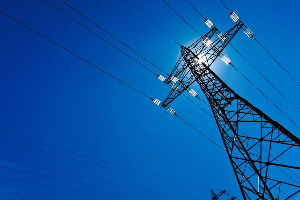 the utility pole of a high voltage line with sun and blue sky. energy supply by power line. 