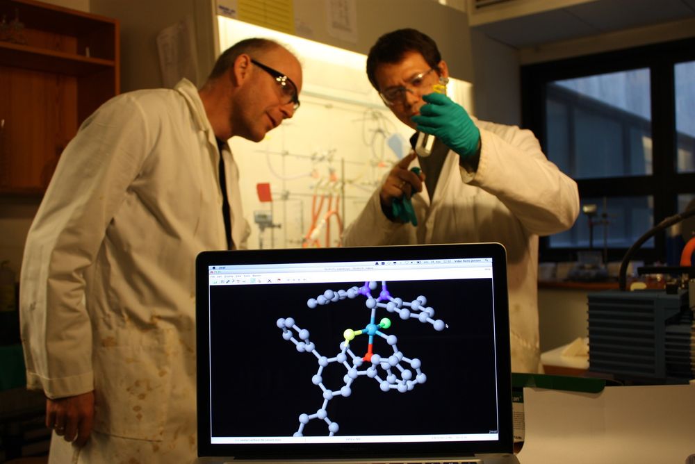 Professor Vidar R. Jensen sammen med forskerkollega Giovanni Occhipinti. På skjermen ser vi en molekylmodell av en av katalysatorene de har laget, med rutenium i blått i midten.  