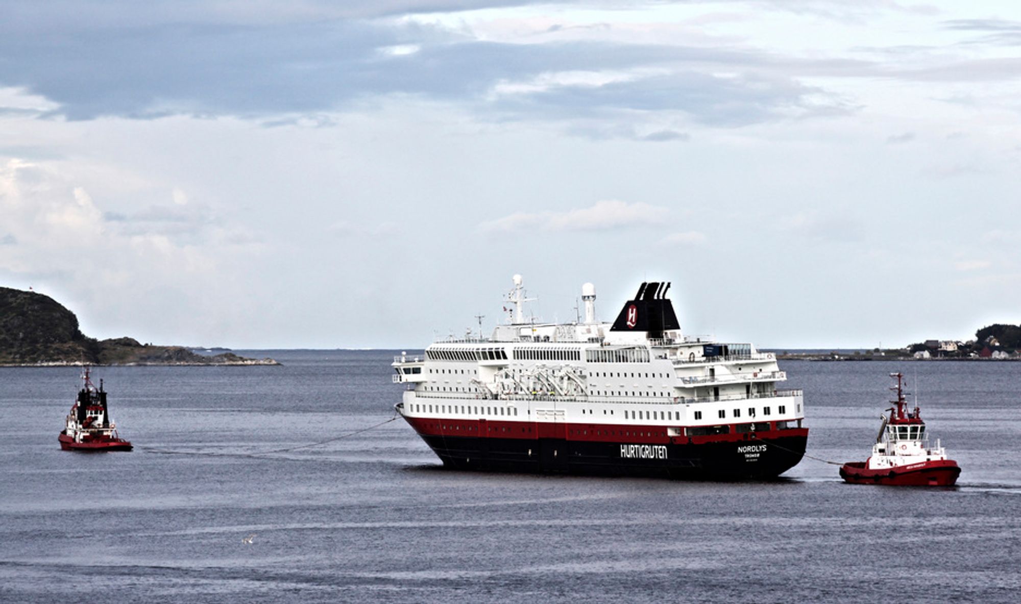 TIL DOKK: Hurtigruteskipet MS Nordlys slepes ut fra havnen i Ålesund etter brannen 15. september.  Slepet ankom verftet i 13-tida.