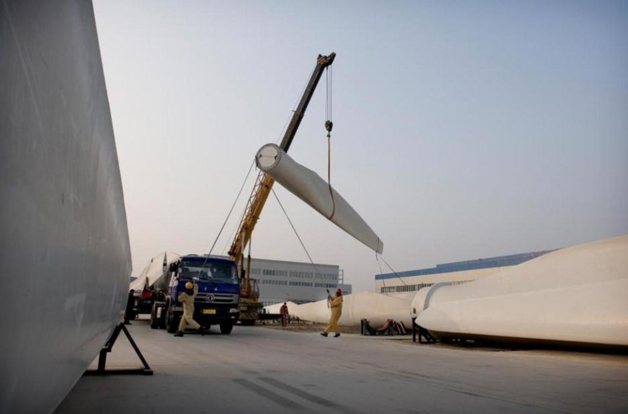 Vindmølleblader produsert i Baoding legges på lastebiler for frakt til vindparker i nordvest-Kina.