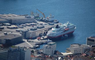 Hurtigruten ved kai i Bergen. Et bunkersfartøy ligger ved siden av. Hurtigruten bruker marin diesel og ikke tungolje.