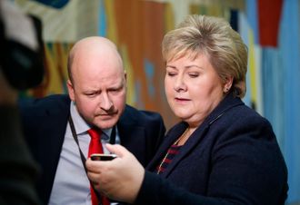 Statsminister Erna Solberg (H) sjekker mobiltelefonen etter spørretimen onsdag, sammen med statssekretær Sigbjørn Aanes.
Foto: Vidar Ruud / NTB scanpix