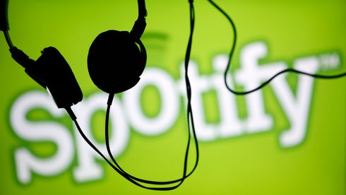Silhuetten av hodetelefoner foran en stor Spotify-logo.