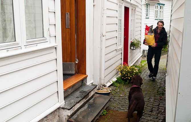 Trond Saure leverer fôr helt hjem på døren til labradoren Leia.