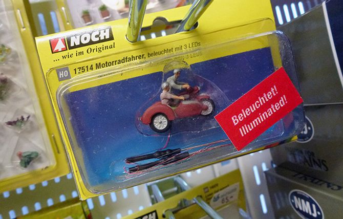 Modelljernbane handler for mange om å skape en ramme rundt det som går på skinner. Det kan både ha et urbant eller mer ruralt tilsnitt. Uansett; en motorsykkel med sidevogn, utstyrt med ledninger og LED-lys, finner seg til rette både på landet og i byen.