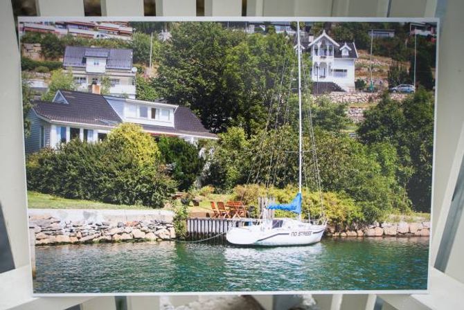 DEN GONG DÅ: Slik såg det ut før fjordstien kom, eigedomen hadde strandlinje og privat brygge. No går fjordstien på framsida av huset, rett utfor brygga der seglbåten ligg fortøyd på biletet. Etter kvart vil den bli bygd vidare rundt og opp på baksida av huset.