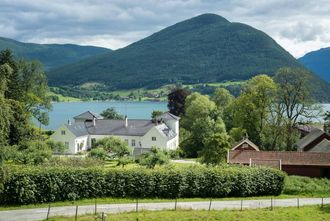 HISTORISK GRUNN: Den nye gravlunda på Kaupanger kjem tett på både stavkyrkja og Kaupanger Hovedgård (biletet), historiske bygg som begge er freda.