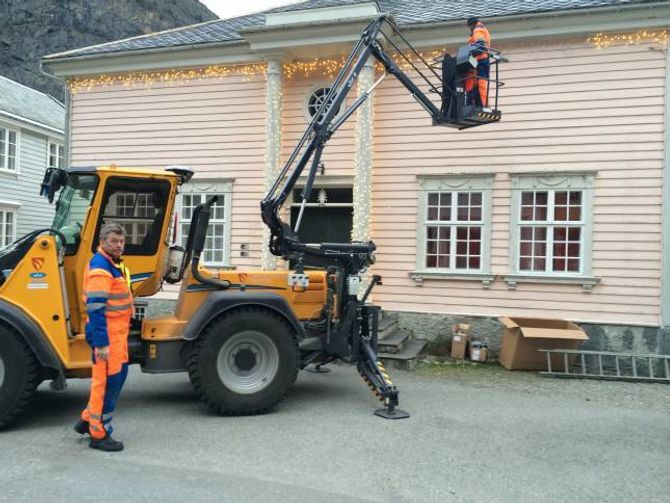 GAMLE BAKERIET: Gunnleif Haugen (frå venstre) og Bjørn Fodnes heng opp lys langs med mønet og stolpane på bygget.