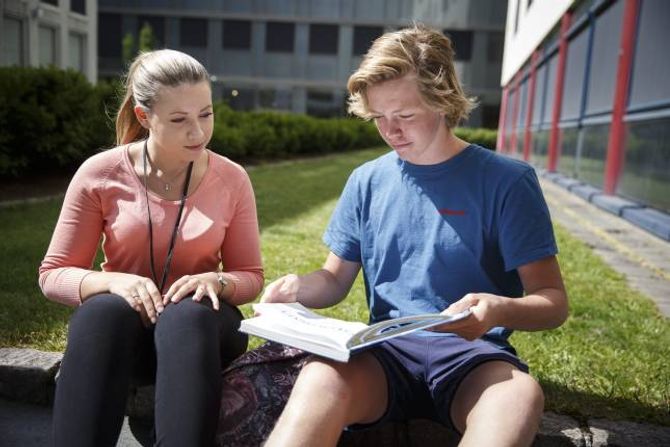 Privatlærer Maja Øvergaard Berge og elev Mathias Vågsdal går gjennom geografiboken.